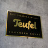 Schild in Schwarz-Gold mit dem Teufel Logo