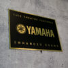 Schild in Schwarz-Gold mit dem Yamaha Logo